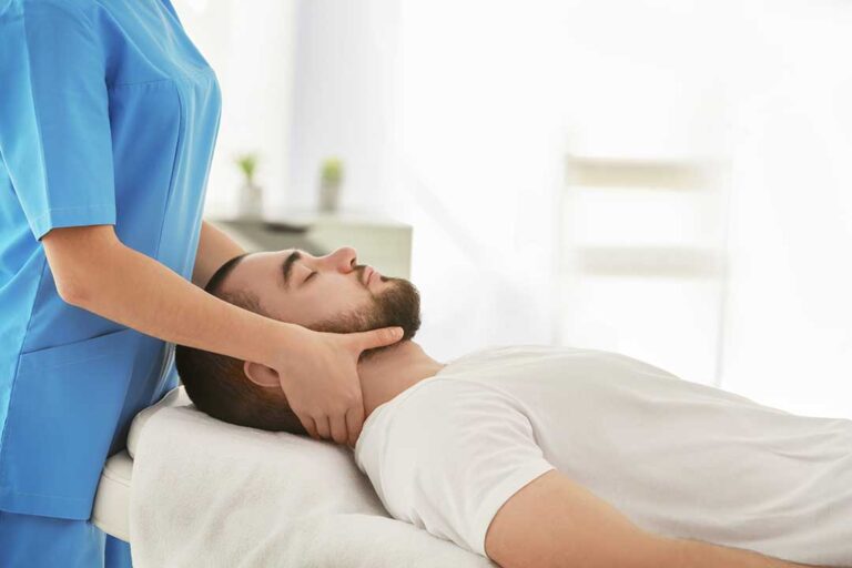 A chiropractor adjusts a patient's upper back in a health clinic setting.