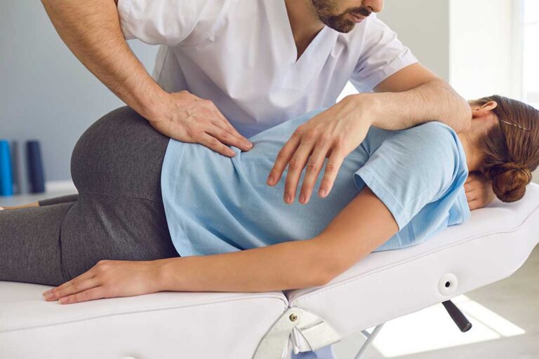 A person receiving a professional back adjustment from a practitioner in a calm clinic setting