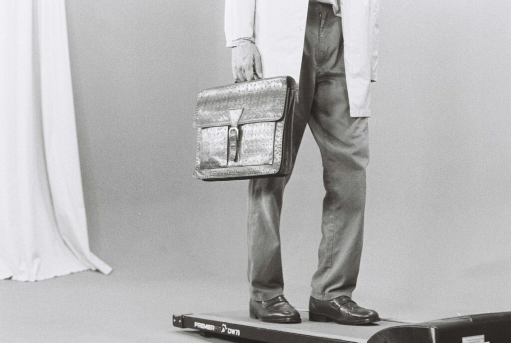 Adult practicing balance beside a sturdy chair while maintaining an upright, neutral posture.