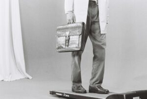 Adult practicing balance beside a sturdy chair while maintaining an upright, neutral posture.